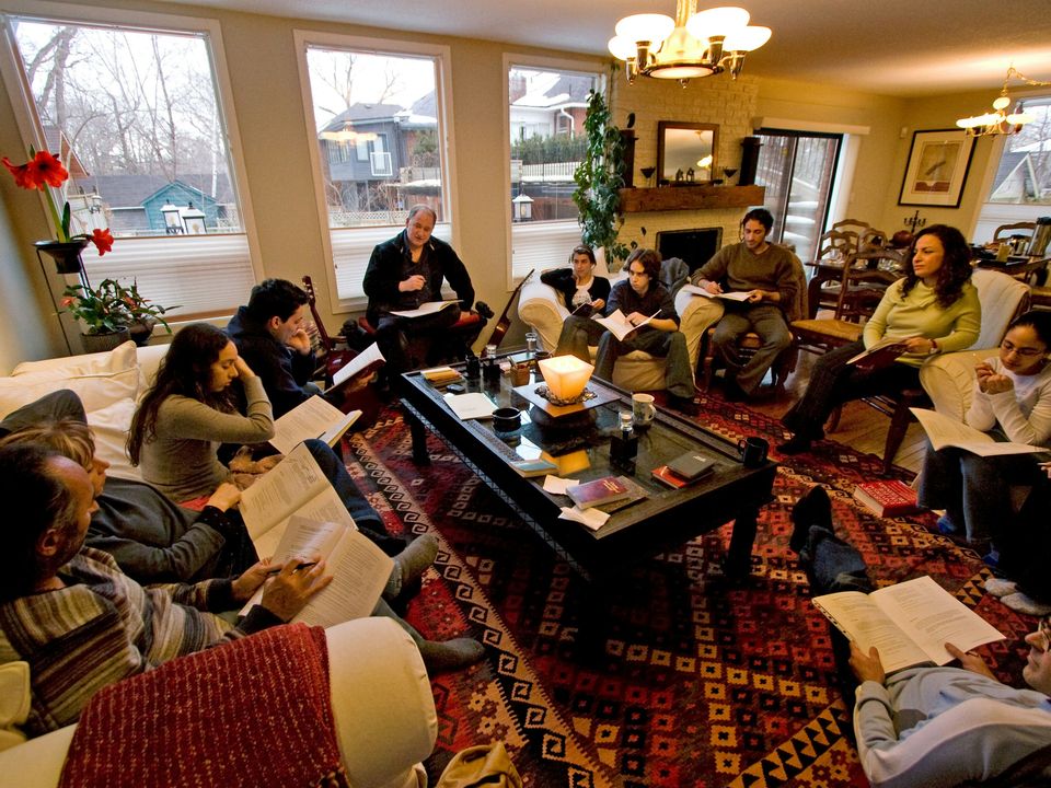 Adults reading and consulting together in a Bahá’í study circle